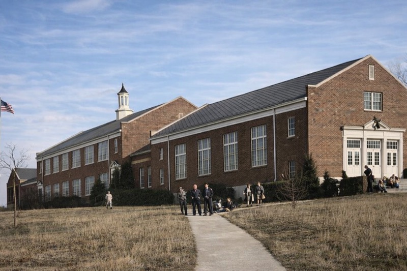 The original Blountville school building — a two-story brick structure with cupola and American flag, students gathered on the front lawn, circa the school's active years